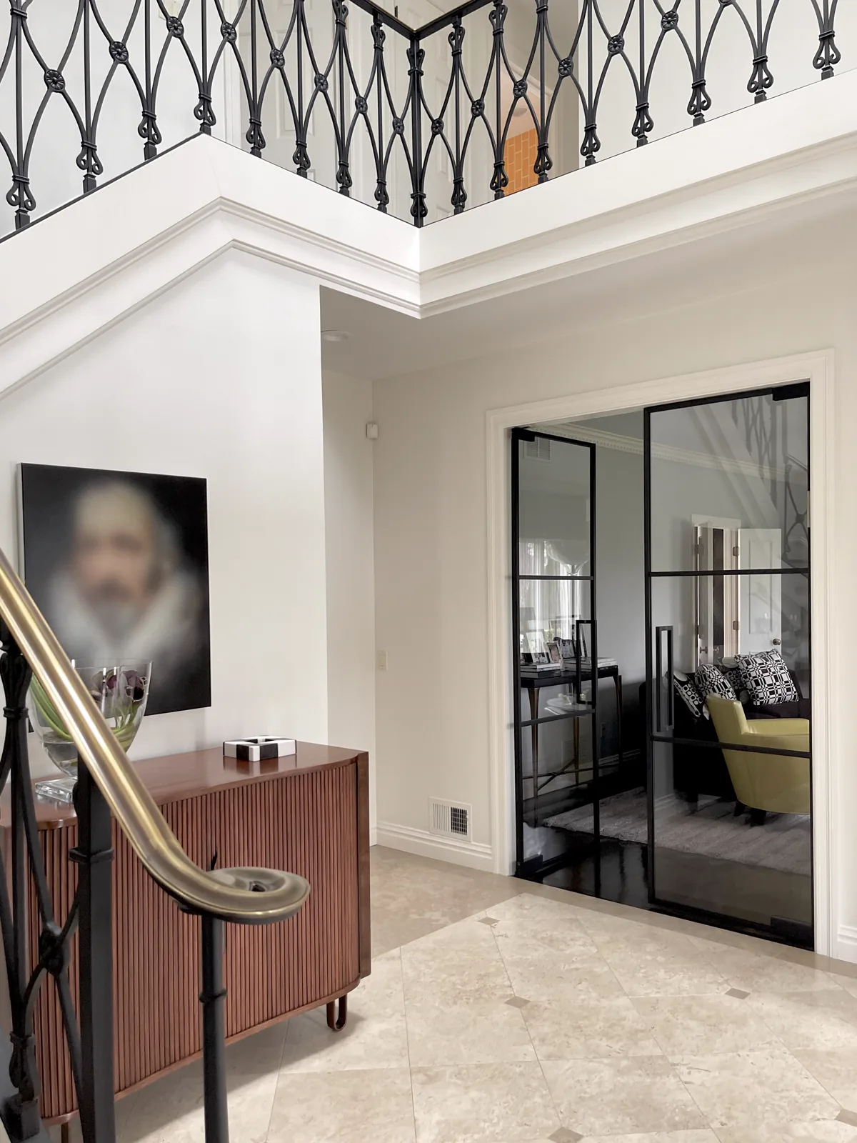 Glass doors seen from a marble foyer beside a staircase
