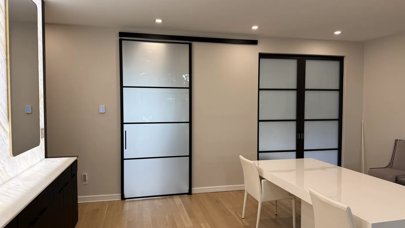 Barn style sliding glass door in frosted glass on an exposed black track